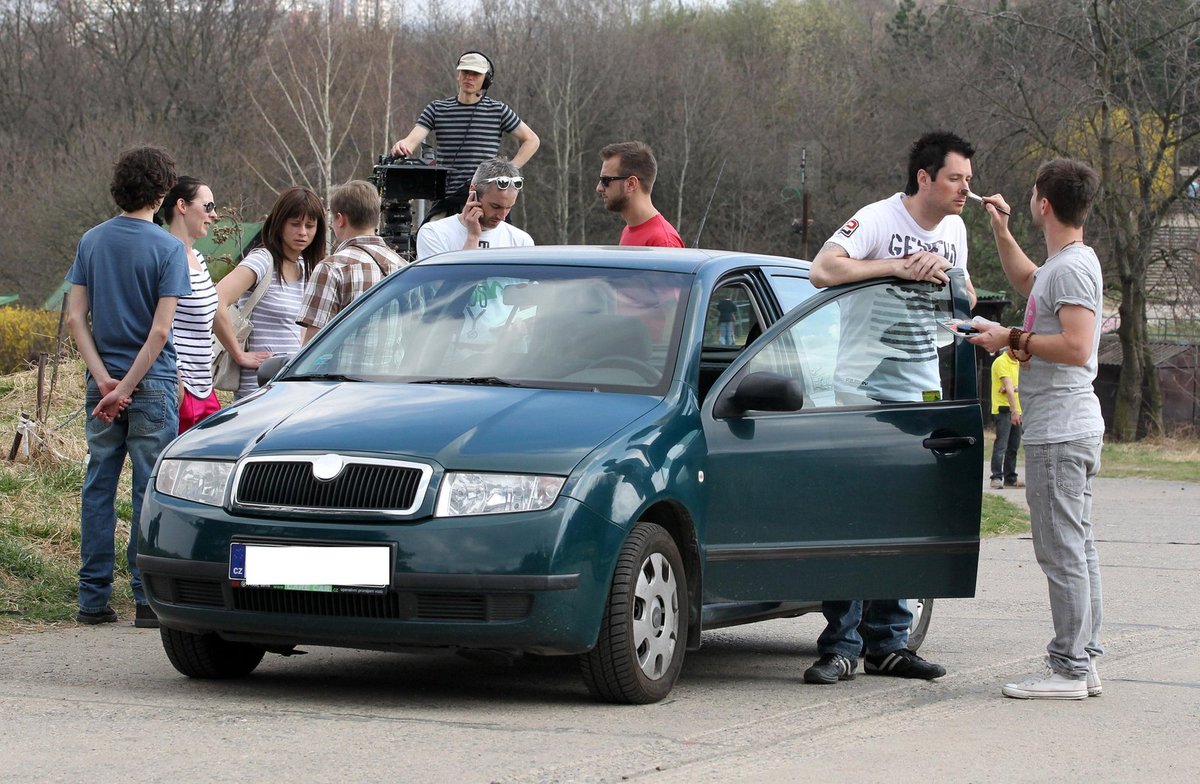 Petr Vágner se lesknul, maskér ho tak musel přepudrovat. Zbytek štábu přihlíží.