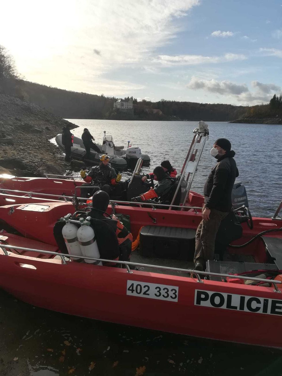 Policejní potápěči spolu s potápěči hasičů propátrávají dno v zátoce poblíž zámku Orlík a hledají zmizelého.