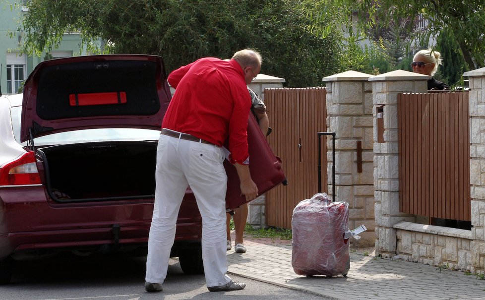Otec Ornelly Michal vykládá kufry před domem v Hostivicích
