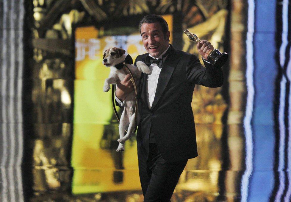 Francouzský herec Jean Dujardin si nese v náruči psa Uggieho. Ten si s ním zahrál ve snímku The Artist