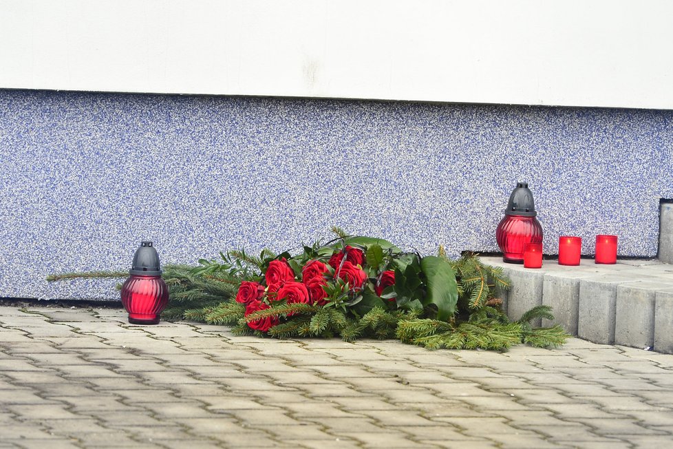 Svíčky a květiny někdo umístil u vchodu firmy na památku tragicky zesnulého Jana B.
