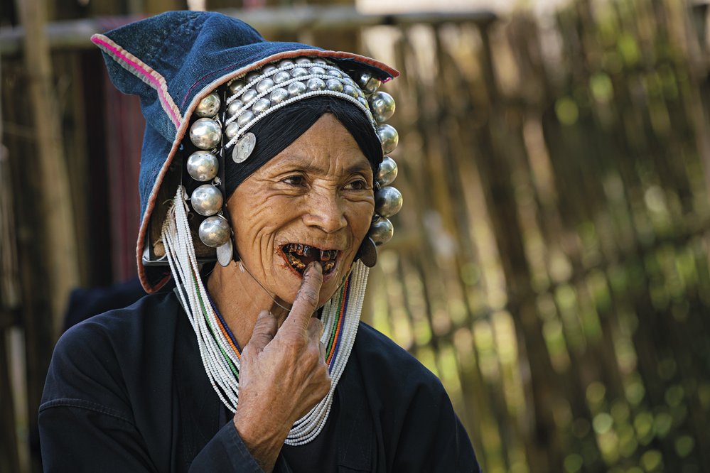 Žena z kmene Akha žijící v horské vesnici nedaleko Kengtungu poukazuje na své načernalé zuby po dlouholetém žvýkání betelu
