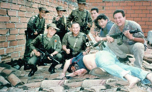 Policisté pózují nad mrtvolou zastřeleného Pabla Escobara.