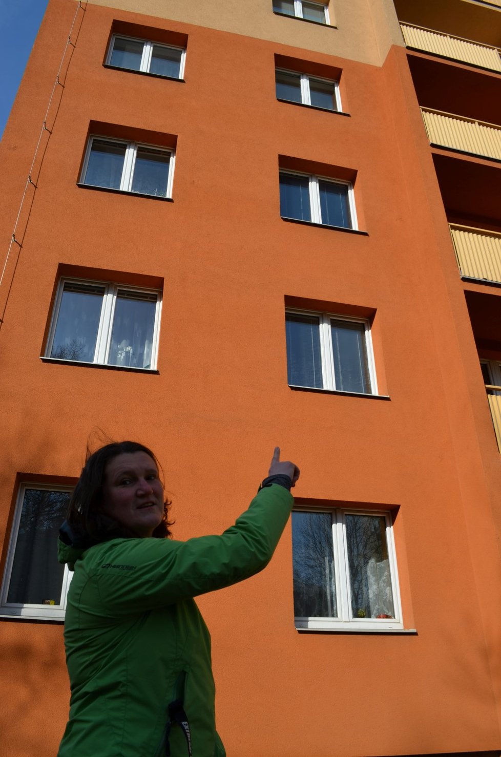 Štěpánka Vlčeková ukazuje okno, odkud Dominik ve středu po poledni vypadl. Jde o poslední patro v hnědé části domu.