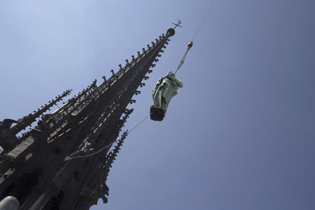 Kvůli rekonstrukci katedrály Notre-Dame bylo přemístěno několik soch světců. Na snímku socha sv. Jana v pozadí věžička, která nepřežila pondělní požár, (16.04.2019).