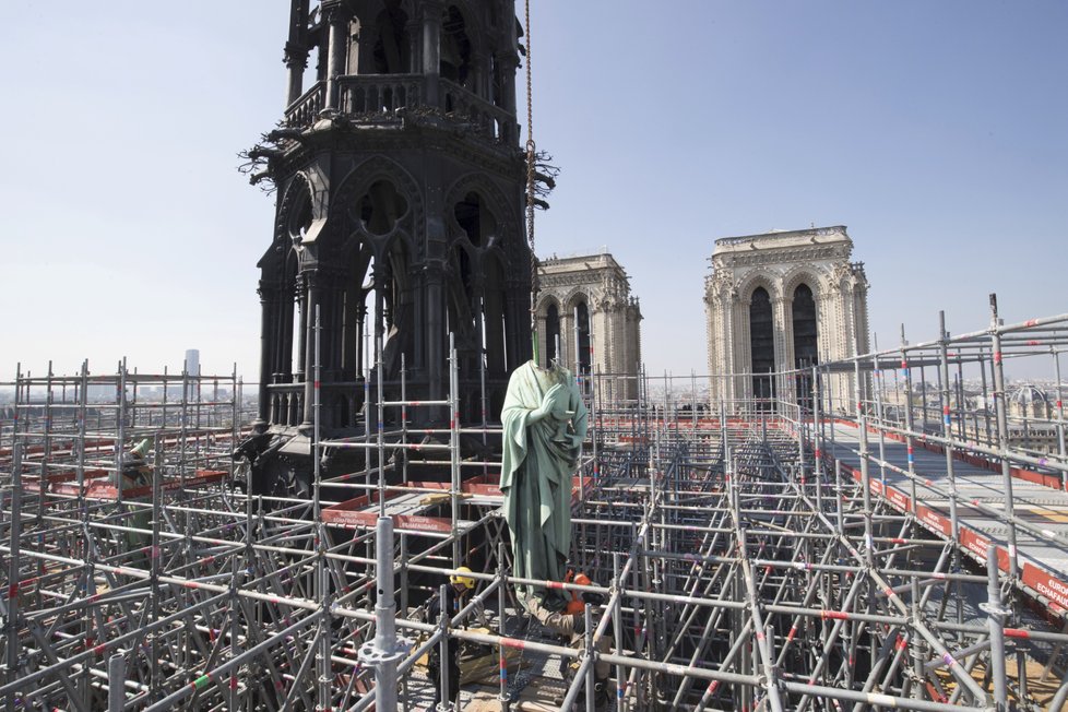 Kvůli rekonstrukci katedrály Notre-Dame bylo přemístěno několik soch světců. Na snímku socha sv. Jana, v pozadí věžička, která nepřežila pondělní požár. (16.04.2019)