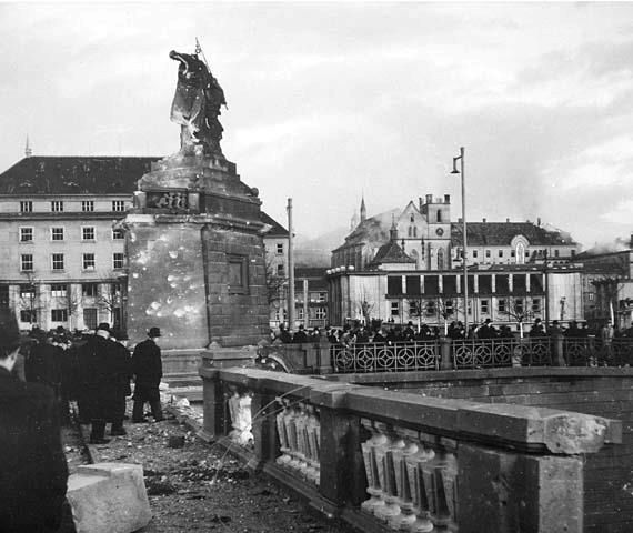 Poškozené sousoší Lumíra a Písně na Palackého mostě po bombardování roku 1945