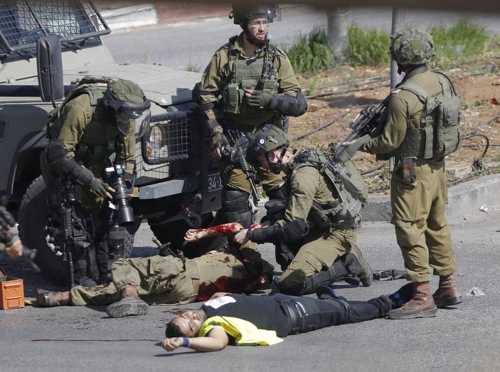 Izraelští vojáci se sklání nad pobodaným kolegou.
