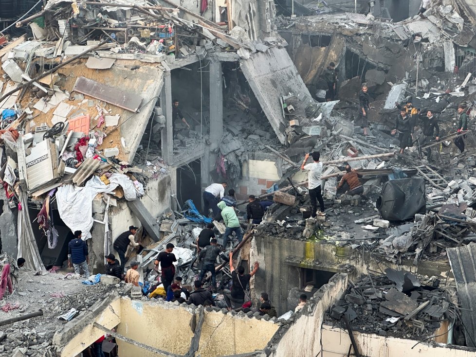 Lidé v palestinském Rafahu prohledávají trosky rozbombardovaných domů (12. 12. 2023).
