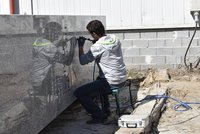 Práce na památníku Díky, Ameriko! finišují: Kamenosochař tesá nápisy do pylonů
