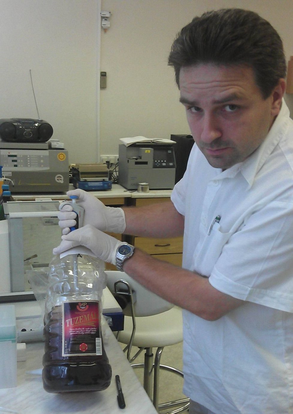 Kriminalistický znalec zkoumá v zabavené plastové láhvi tuzemáku přítomnost metanolu.