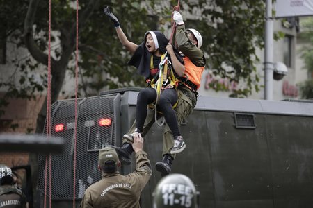 Demonstrace při příletu papeže do Chile: Aktivistky se převlékly za jeptišky a policisté je museli stahovat z výšky.