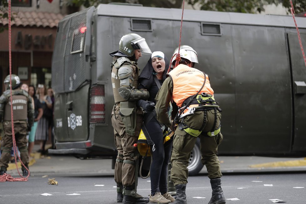 Demonstrace při příletu papeže do Chile: Aktivistky se převlékly za jeptišky a policisté je museli stahovat z výšky.