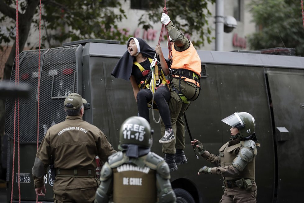 Demonstrace při příletu papeže do Chile: Aktivistky se převlékly za jeptišky a policisté je museli stahovat z výšky.