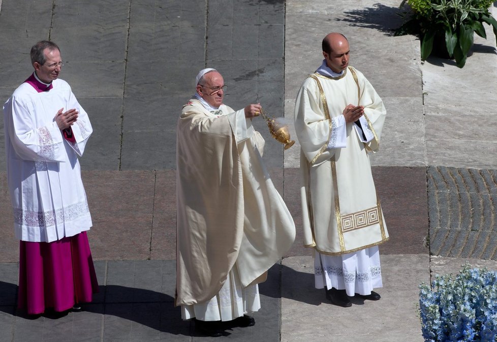 Papež František houpe s kaditelnicí při sloužení velikonoční mše doprovázen dvěma ministranty.