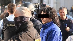 Policisté přivádějí muže v poutech k Okresnímu soudu v Pardubicích po požáru haly (24.3.2026)