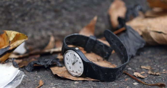 Rozbité hodinky po pátečních útocích leží na ulici.