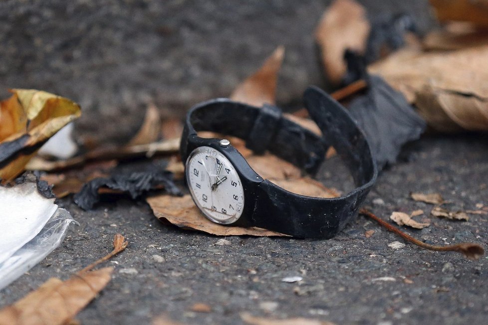 Rozbité hodinky po pátečních útocích leží na ulici.