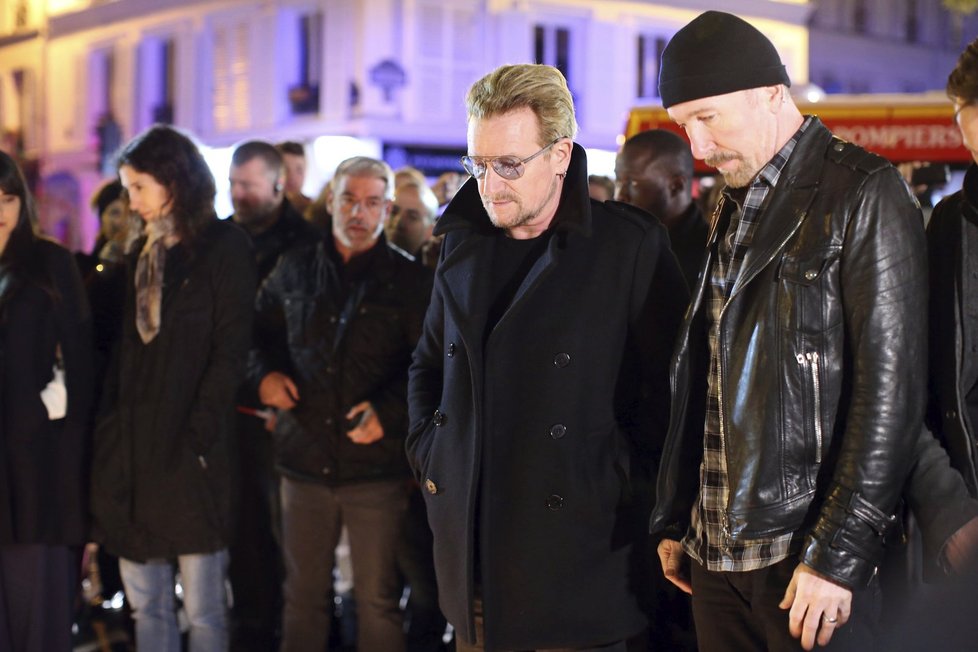 Členové kapely U2 uctívají památku pařížských padlých po útocích 13. 11. tím, že před klub Bataclan pokládají květiny.