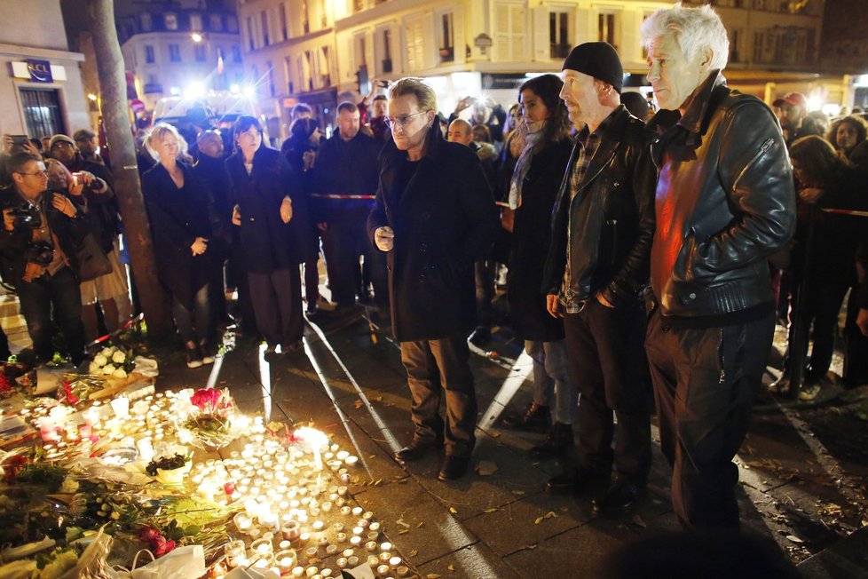 Členové kapely U2 uctívají památku pařížských padlých po útocích 13. 11. tím, že před club Bataclan pokládají květiny.