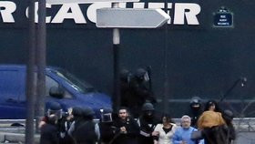 Policie vyvádí osvobozená rukojmí z košer obchodu, kde je držel terorista