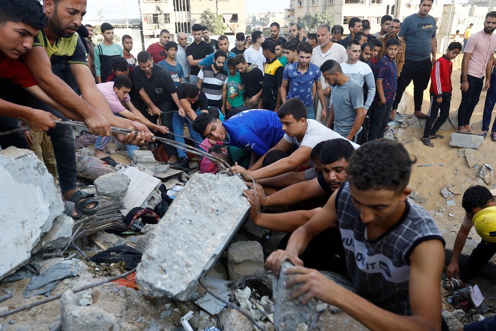 Lidé se na jihu Pásma Gazy snaží vyprostit lidi pod sutinami (16. 10. 2023).