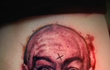 Vytetovaný portrét Charlese Mansona na noze.