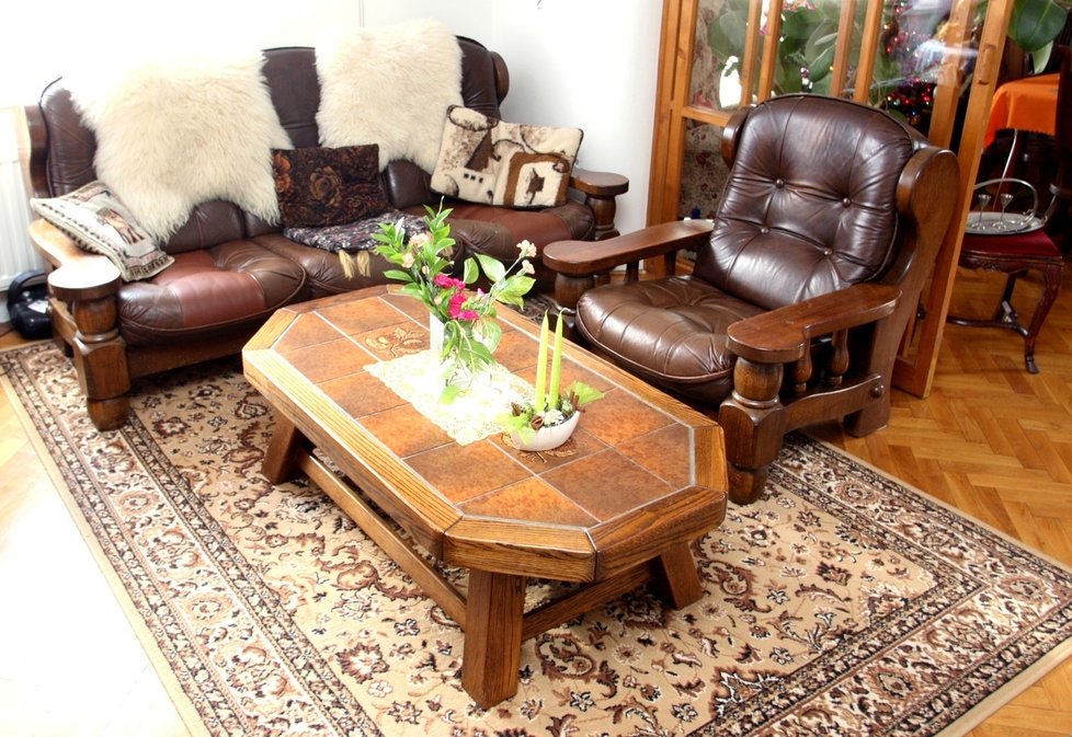 V obýváku má herec tmavě hnědou koženou pohovku, stůl z masivního dřeva a pod ním perský koberec.