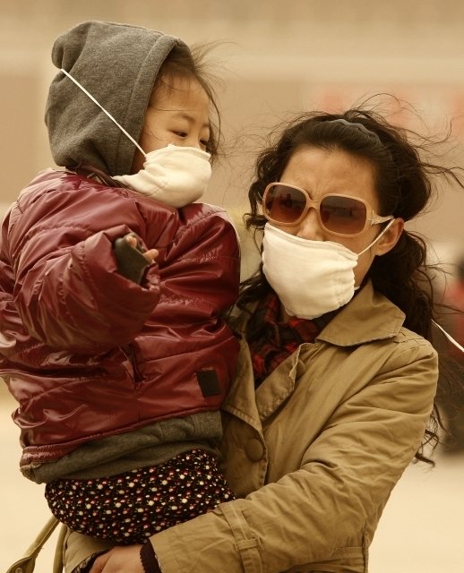 Lidé v Pekingu si museli kvůli písku zakrývat obličeje rouškami.