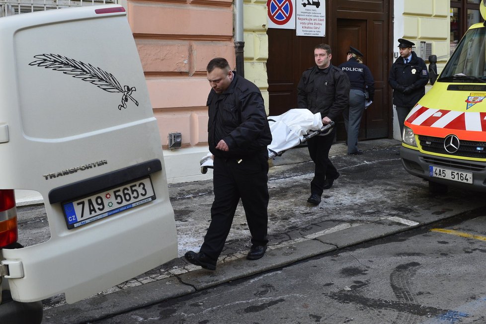 Pracovníci pohřební služby odnáší tělo batolete do pohřebního vozu.