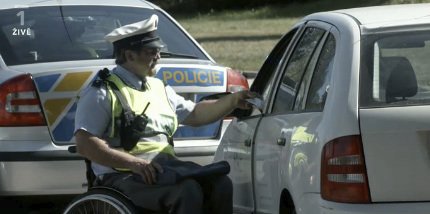 Jan Potměšil coby policajt na vozíku kontroluje řidičům doklady.