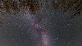 Oranžově zářící Mars a Měsíc nízko nad obzorem . Mléčná dráha zde vypadá jako nebeská brána.
