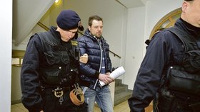 Petra Kramného odvádějí policisté k soudu, který rozhodl o jeho vzetí do vazby.