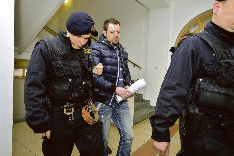 Petra Kramného odvádějí policisté k soudu, který rozhodl o jeho vzetí do vazby.