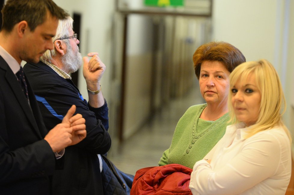 Obhájkyně Petra Kramného se radí na chodbě před soudní síní s rodiči Petra.