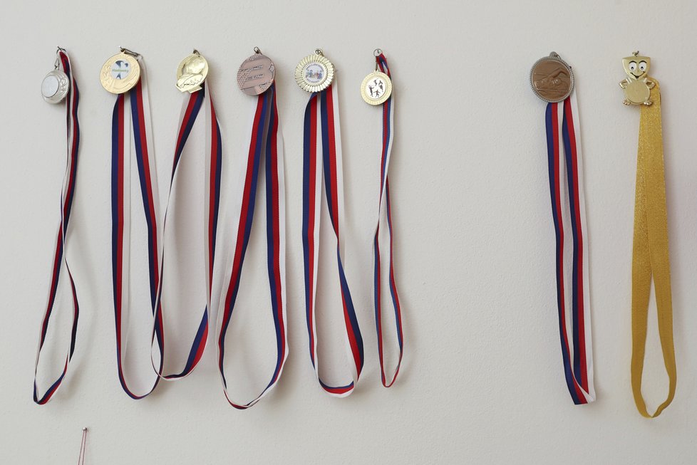 Medaile má pověšené v pokoji na zdi.