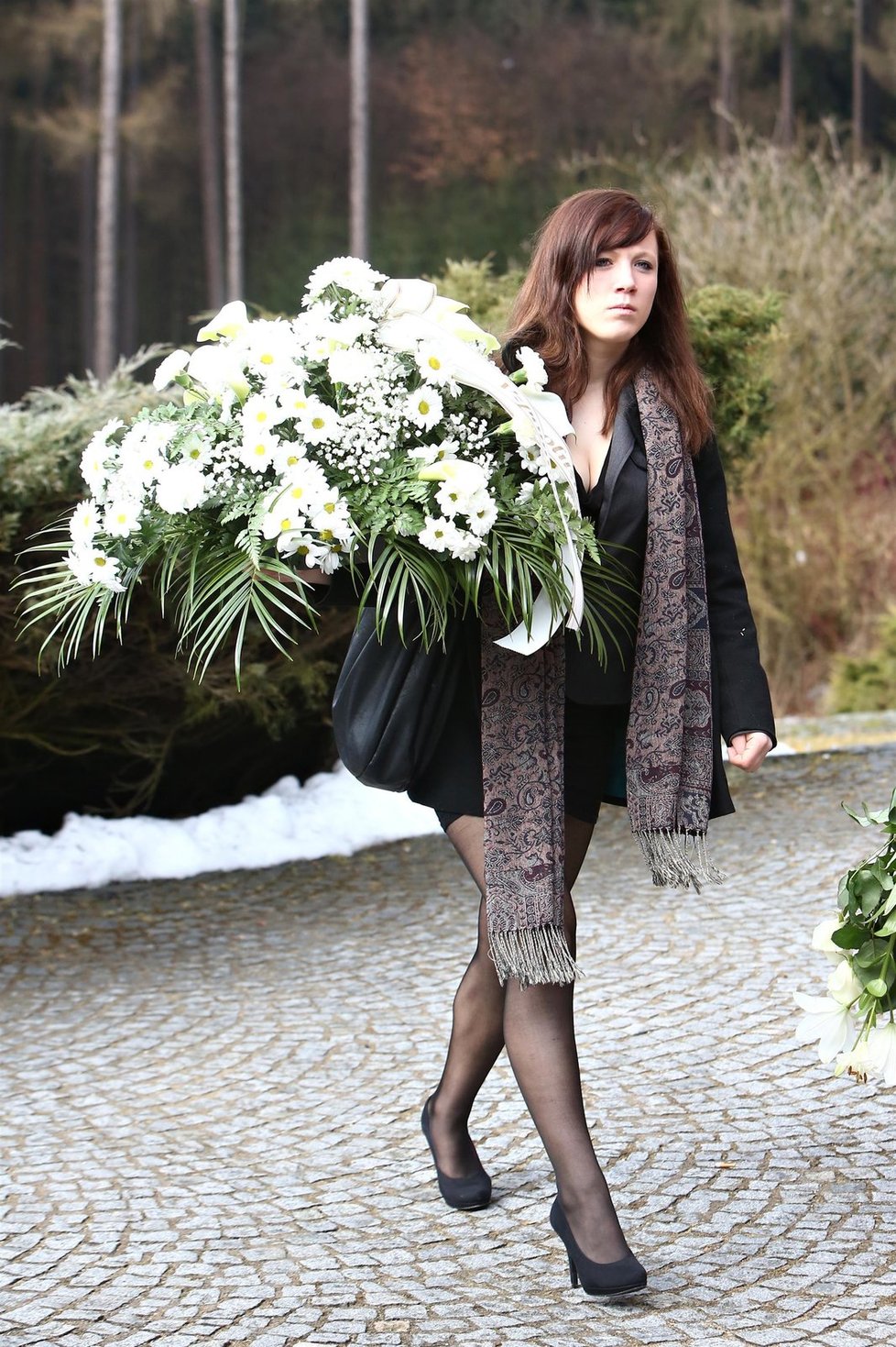 Rodina a kamarádi Petry přinesli na pohřeb řadu bílých květin.