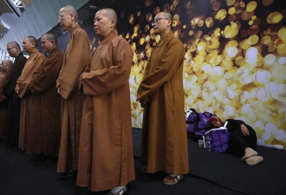 Buddhističí mniši se modlí za všechny cestující, kteří byli na palubě.