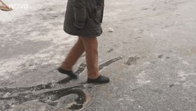 Aby nemohli lidé bruslit na rybníku v zámeckém parku v Třešti, posypal zaměstnanec led pískem.