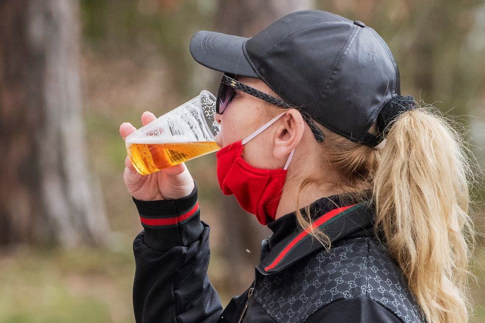 Žena pije pivo 4. dubna 2020 v teplém jarním odpoledni u Boleveckého rybníka v Plzni.