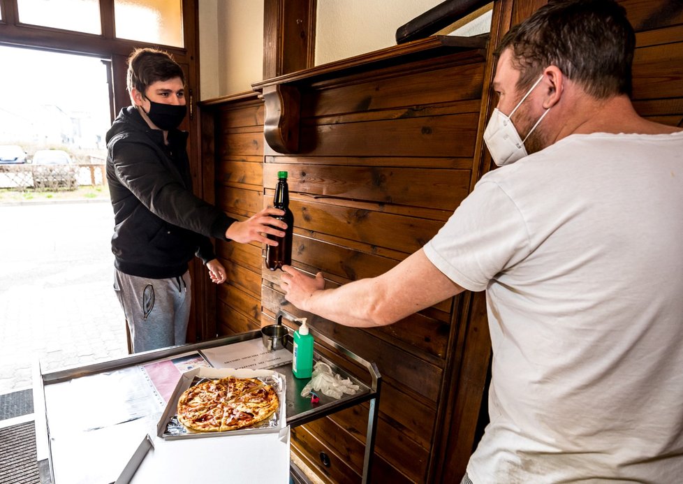 Zákazník si 4. dubna 2020 odnáší jídlo a pivo z jedné z restaurací v Ústí nad Labem.