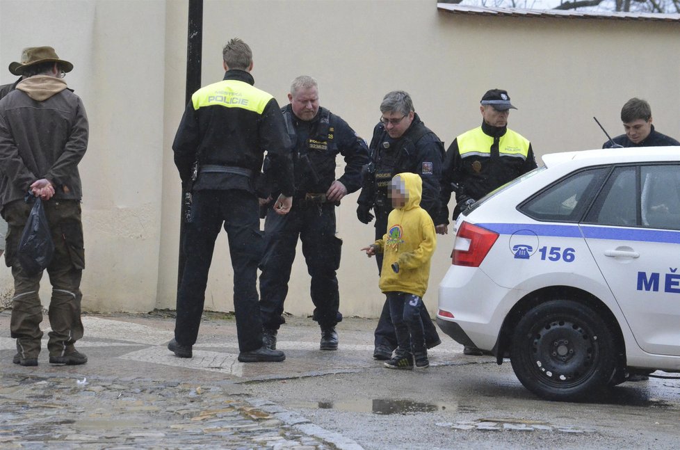 Jednoho z výtržníků odvádějí policisté.