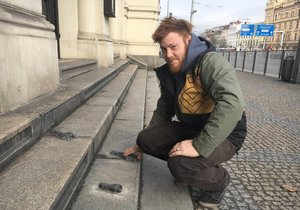 Umělec Lukáš Řezníček u díla Stopy, které nainstaloval na schody Velké synagogy v Plzni.