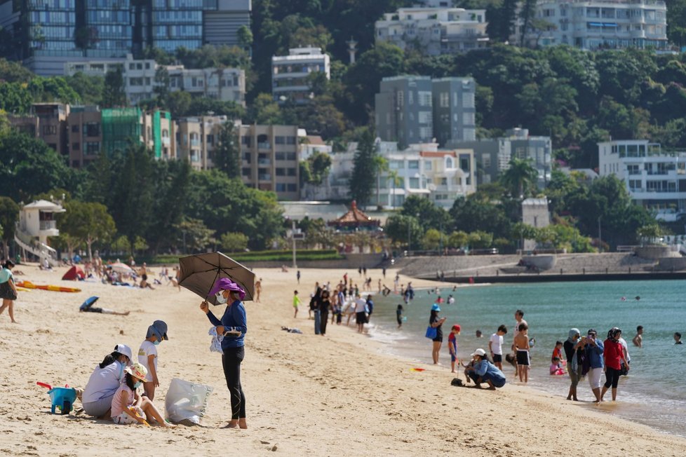 Lidé si i během koronavirové pandemie užívají teplého počasí na pláži v Hongkongu. (22. 11. 2020)
