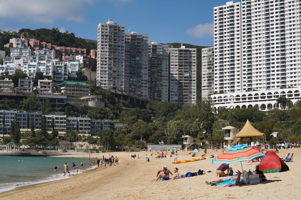 Lidé si i během koronavirové pandemie užívají teplého počasí na pláži v Hongkongu. (22. 11. 2020)