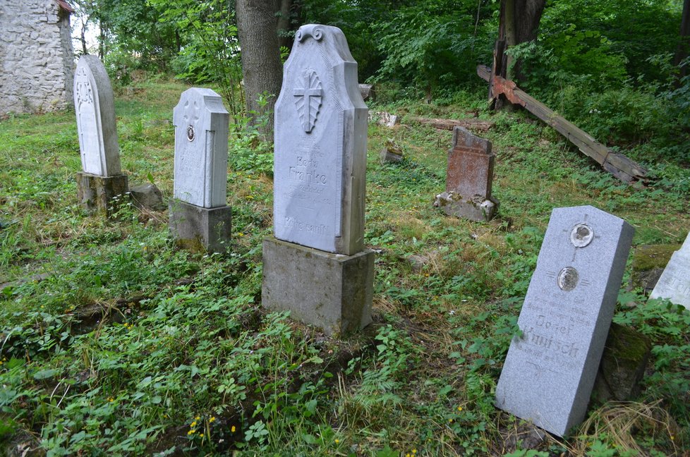 Torza náhrobních kamenů starousedlíků u kostela.