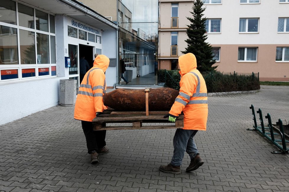 Leteckou bombu přivezenou starostou přenášejí do budovy radnice městské části Doubravka.