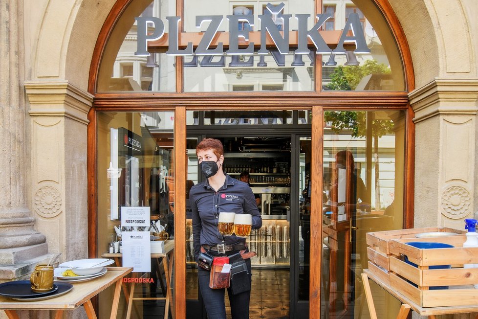 Servírka nese půllitry s pivem hostům na zahrádce plzeňské restaurace Plzeňka, která po rozvolnění protiepidemických opatření otevřela také vnitřní prostory (31. 5. 2021)