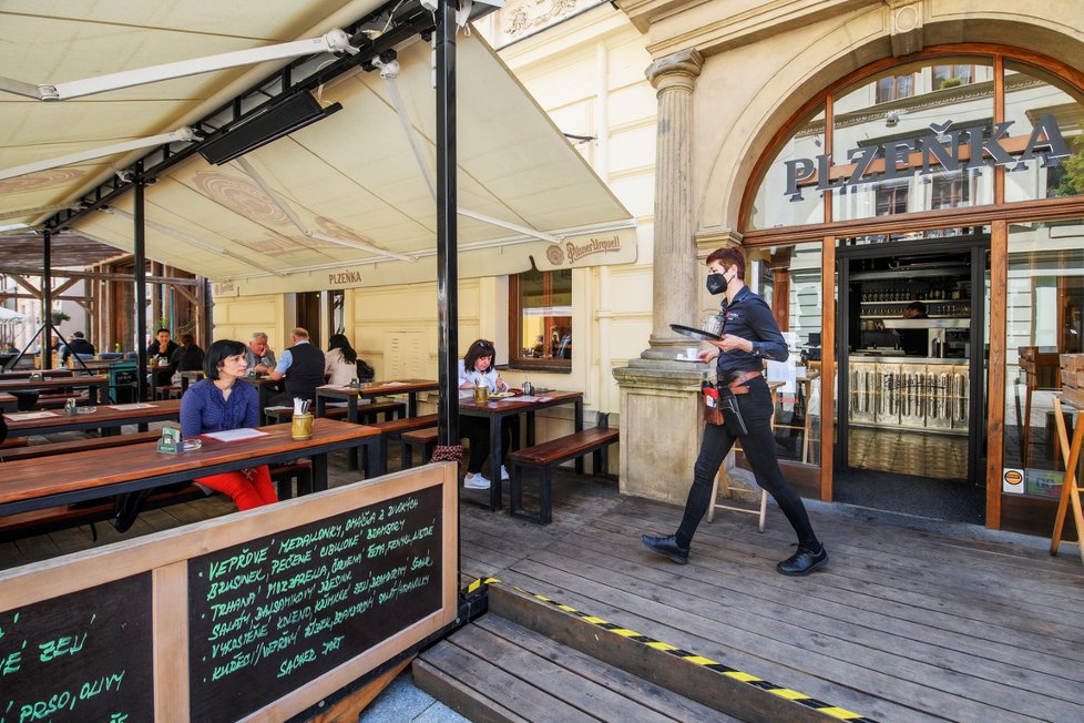 Servírka obsluhuje hosty na zahrádce plzeňské restaurace Plzeňka, která po rozvolnění protiepidemických opatření otevřela také vnitřní prostory (31. 5. 2021)