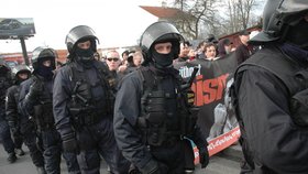 Policejní těžkooděnci v hlídají členy krajní pravice při průchodu Solní ulici.